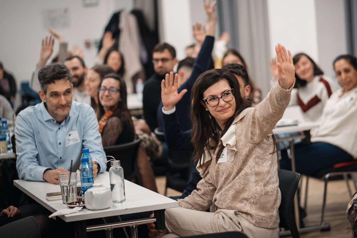 Participants raising their hands in response to a question from the facilitator